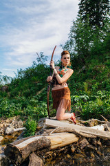 Young beautiful amazon girl hunting in the forest