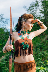 Young beautiful amazon girl hunting in the forest