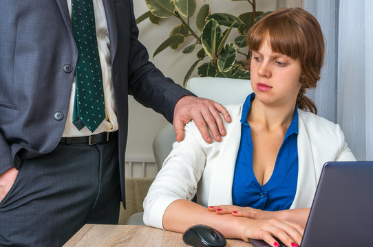 Man touching woman's shoulder - sexual harassment in office