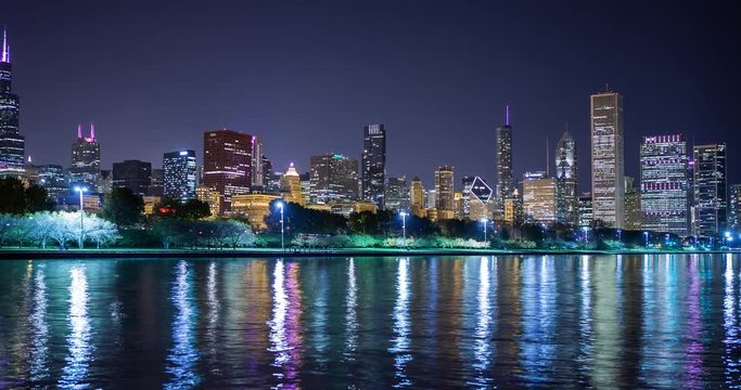 Chicago, Illinois, USA - view from the Lakefront Trail at the Field Museum / Shedd Aquarium facing north at shore of Lake Michigan and the skyline at night - Timelapse with zoom in 