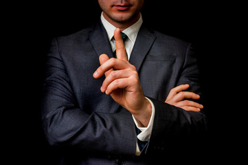 Businessman showing one finger, making silence gesture