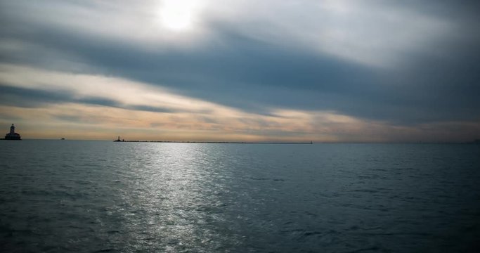 Chicago, Illinois, USA - view from Navy Pier facing Lake Michigan with lighthouse and boats after sunrise - Timelapse with zoom out 