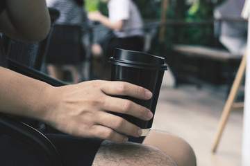 Fototapeta na wymiar Close-up of male hand holding coffee to take away, vintage tone.