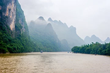 Fotobehang Li River with misty clouds, China © dinozzaver