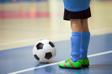 Football futsal training for children. Indoor soccer young player with a soccer ball in a sports...
