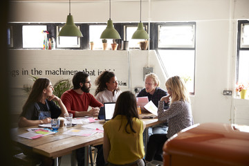 Group Of Designers Meeting Around Table In Modern Office