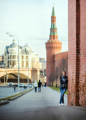 Attractive woman stay near the Kremlin wall on Red Square, Moscow, Russia. Cold season.