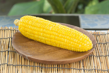 Boiled sweet corn on the wooden plate