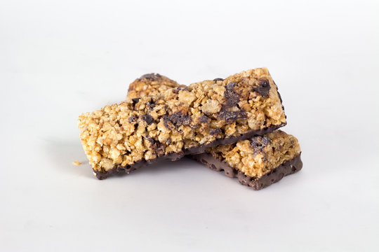 Barrette ai cereali con cioccolato su sfondo bianco isolate