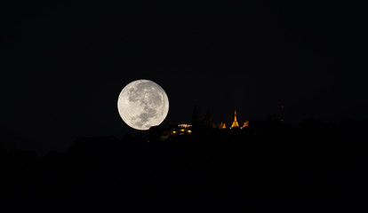 Fototapeta na wymiar silhouette shot image of big moon at temple.