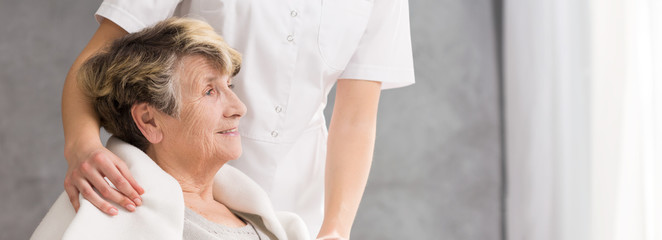 Nurse standing behind senior woman