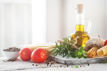 Healthy ingredients on a kitchen table - spaghetti, olive oil, t