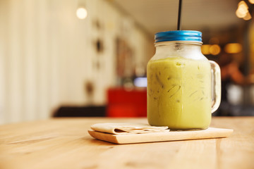 Ice green tea frappe glass on wood table.