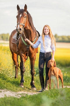 Young lady with a horse and vizsla dog.