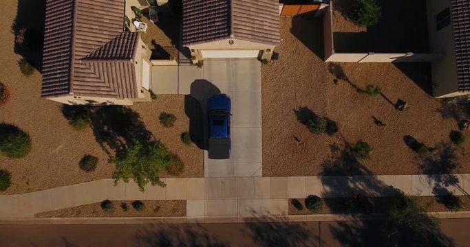 A unique aerial view of a truck pulling into a typical Arizona neighborhood residence. Phoenix suburb.  	