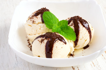 Ice cream with chocolate topping and mint close-up