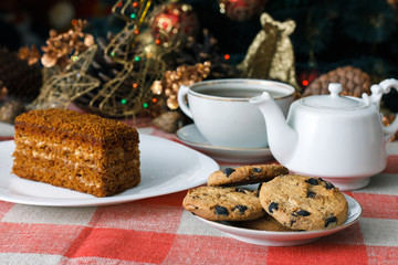 Homemade cookies in a plate on the feast of the new year, christmas. Tasty cookies on a table with a Christmas tree in the background. Tea.