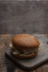 Fresh home-made hamburger served on wood. Wooden background. Tasty hamburger with chicken.