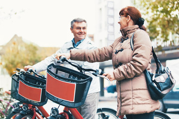 Senior couple renting bike.