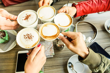 Friends group toasting cappuccino and milk with cocoa