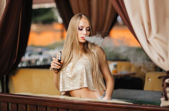 Portrait of sexy young vaping girl. Vapor concept. Vaping e-Cigarette
