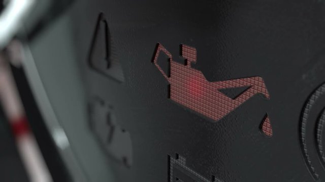 An extreme closeup of a blinking check oil dashboard light on an dashboard panel background