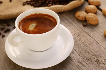 Cup of hot coffee on wooden surface