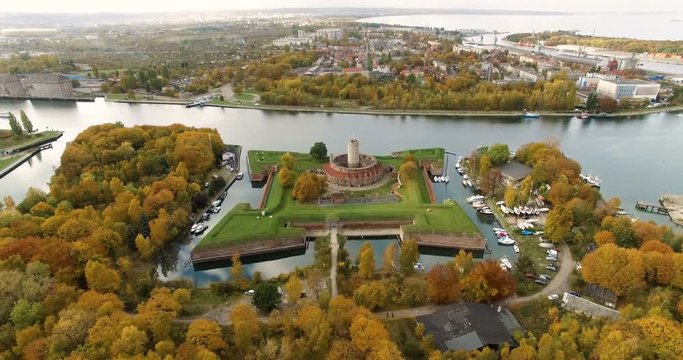 Aerial 4K Bird eye view on historic brick moated fortress Wisloujscie on the Martwa Wisla River estuary with Bay of Gdansk autumn panorama