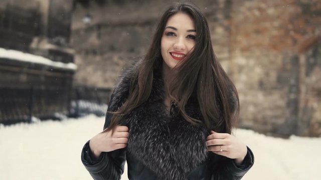 City walking of beautiful brunette girl, having fun in snowy winter time