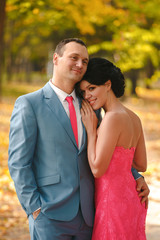 Young bridegroom gentle hugs his beautiful bride.