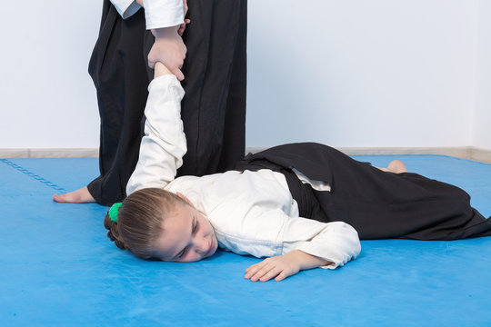 Two girls in black hakama practice Aikido. Selective focus
