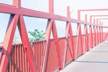 Red bridge with metal structure. Lines in perspective, long pedestrian crossing.