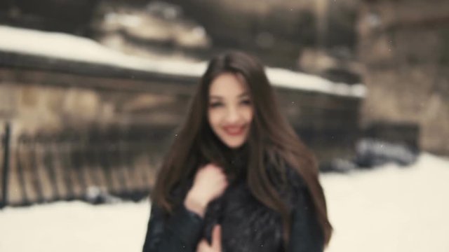 City walking of beautiful brunette girl, having fun in snowy winter time
