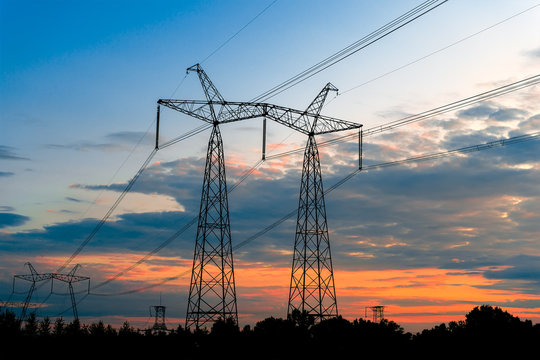 Electricity pylons at sunset with power horizon.