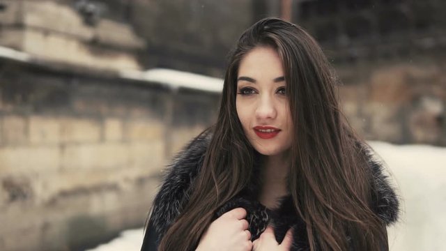 Portrait of beautiful brunette girl, having fun in snowy winter time