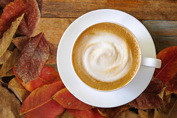 Top view of hot coffee cappuccino cup with milk foam on wood tab