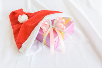 gift with color bow in a christmas hat on white cloth background