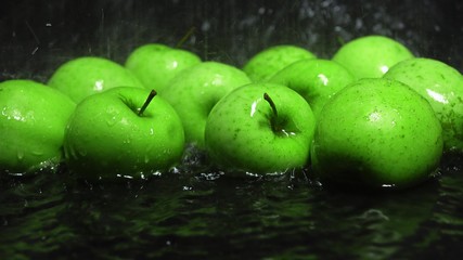 Green apples in water being washed