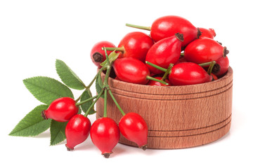 rosehip berries in a wooden bowl isolated on white background