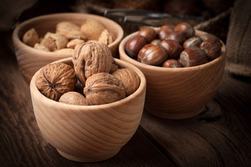 Walnuts, hazelnuts and almonds in-shell in wooden bowl.