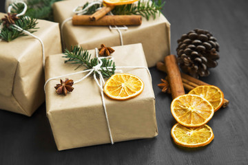 Fototapeta na wymiar Christmas retro wrapped gifts with dried orange slice and fir tr
