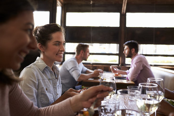 Two female friends at a girls’ lunch in a busy restaurant