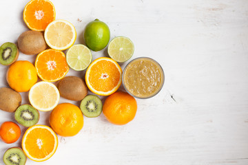 Smoothie rich in vitamin C made with oranges, lemons, limes, clementines, kiwis, top view, selective focus