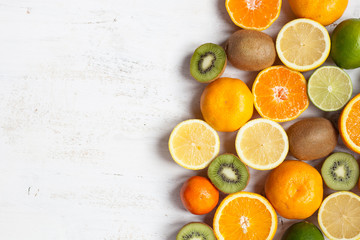 Fruits rich in vitamin C: oranges, lemons, limes, clementines, kiwis, top view, selective focu; copy space for text