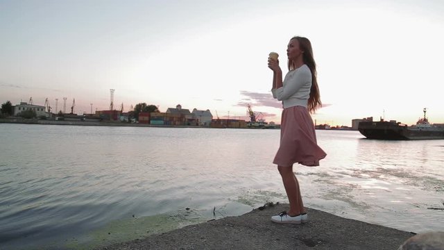 woman drink cofee watching at sunset jumping and dancing river port