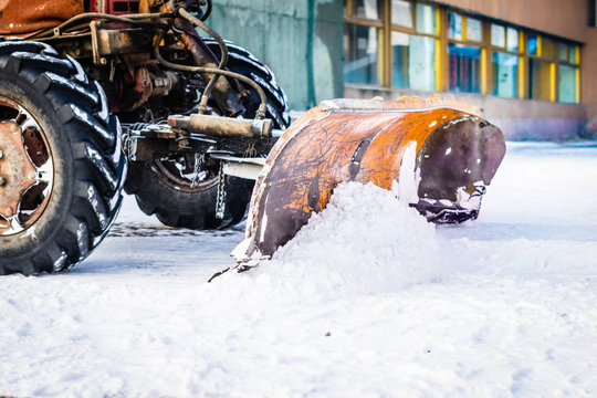 Old snow clearing machine hanging on a tractor