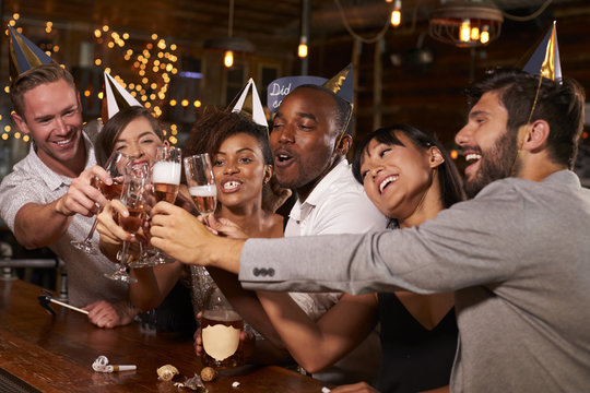 Friends toasting with champagne at New Year’s party in a bar