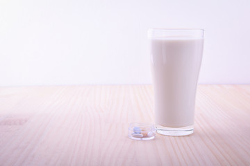 medicine pill and milk on table soft focus