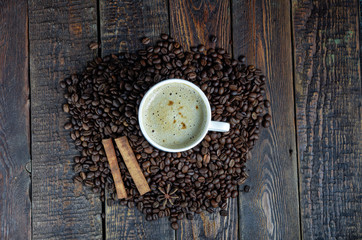 Coffee cup with cinnamon sticks and anis star on old rustic table. Top view