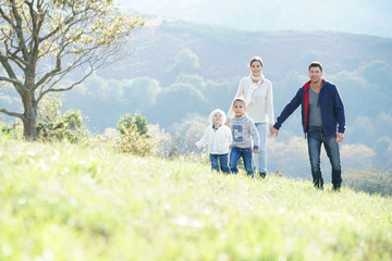 Happy family walking in countryside on autumnal week-end